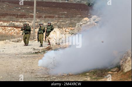 Naplouse, Palestine. 23rd décembre 2022. Des soldats israéliens sont placés lors d'affrontements avec des manifestants palestiniens à la suite d'une manifestation contre l'expansion des colonies juives dans le village de Beit Dajan, en Cisjordanie, à l'est de Naplouse, le 23 décembre 2022. Credit: Ayman Nobani/Xinhua/Alamy Live News Banque D'Images