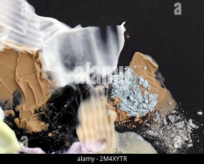 Gros plan sur des taches de crème, de rouge à lèvres et d'ombres. Composition abstraite de divers cosmétiques. Nuances de maquillage crème. Taches texturées, couché à plat Banque D'Images
