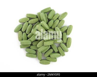 Pilules ovales vertes sur fond blanc. Comprimés gros spiruline. Supplément alimentaire sous forme de comprimés vue du dessus. Banque D'Images