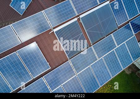 Toiture de bâtiment avec rangées de panneaux photovoltaïques bleus et capteurs solaires d'air sous vide pour le chauffage de l'eau et la production d'électricité écologique propre Banque D'Images