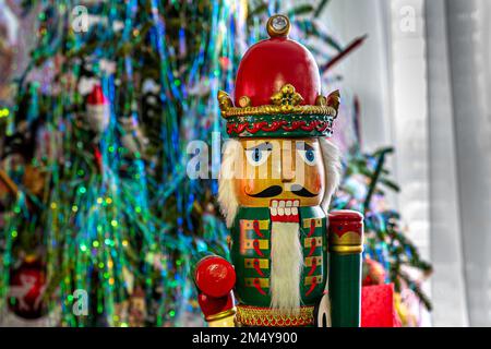 Casse-noisette soldat en bois debout, casse-noisette emblématique. Debout sur le fond d'un arbre de Noël. Banque D'Images