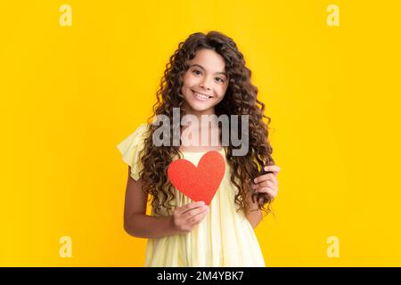 Joyeux portrait d'adolescent. Saint-Valentin. Rêvant enfant adolescent mignon avec coeur rouge. Fille souriante. Banque D'Images