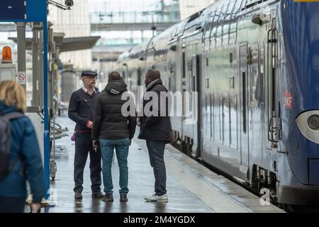 Lille, France. 23rd décembre 2022. Un chef d'orchestre s'entretient avec des passagers sur une plate-forme à la Gare Lille Flandres à Lille, dans le nord de la France, le 23 décembre 2022. La compagnie ferroviaire nationale française SNCF a déclaré être parvenue vendredi à un accord avec les syndicats du pays pour éviter de nouvelles grèves pendant le week-end du nouvel an. Cependant, les déplacements resteront perturbés ce week-end, avec environ un TGV sur trois annulé. Credit: Sebastien Courdji/Xinhua/Alay Live News Banque D'Images