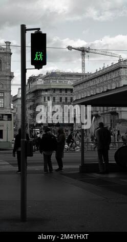 Vue verticale en niveaux de gris d'un feu de circulation avec des icônes humaines vertes tenant les mains. Concept d'amour. Banque D'Images