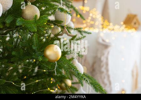 Arbre de Noël décoré avec des jouets de boule d'or sur un fond de conte de fées flou, étincelant et fabuleux avec beau bokeh, espace de copie. Banque D'Images