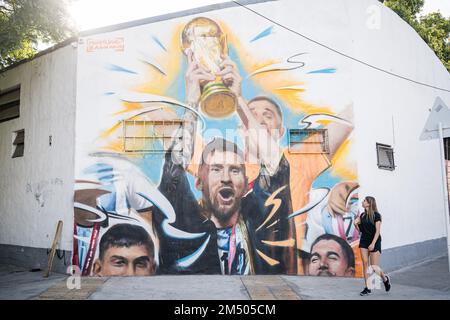 Buenos Aires, Argentine. 23rd décembre 2022. Une femme regarde la fresque de Lionel Messi levant la coupe du monde à Buenos Aires. L'artiste argentin Maximiliano Bagnasco est le premier à capturer le triomphe de l'Argentine au Qatar 2022 dans une fresque où Lionel Messi est vu lever la coupe du monde de la FIFA dans le quartier de Palerme, Buenos Aires. (Photo de Diego Radames/SOPA Images/Sipa USA) crédit: SIPA USA/Alay Live News Banque D'Images