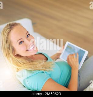 J'ai commencé mon propre blog sur la grossesse. Portrait d'une femme enceinte utilisant une tablette numérique à la maison. Banque D'Images