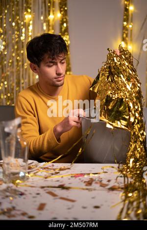 Un jeune homme qui nettoie la maison après la fête du nouvel an. Copier l'espace Banque D'Images