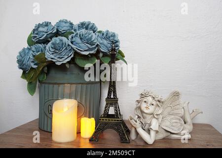 Étagères en bois décorées avec un souvenir de la tour Eiffel, une bougie LED et une petite statue d'ange Banque D'Images