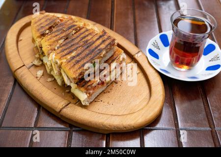 Toast et thé turc ou noir. Thé turc, pain grillé ou sandwich sur une table. Banque D'Images