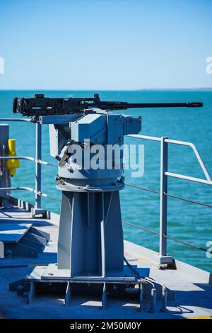 Image couleur d'une mitrailleuse automatique sur le pont d'un navire militaire, en mer. Banque D'Images