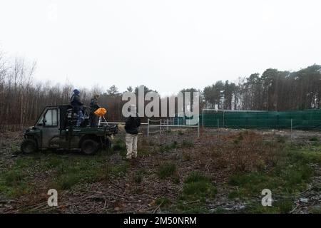 Équipe de conservation en attente de l'émergence du bison des taureaux du corral, tôt le matin, jour de la libération à Blean Woods, Kent, Royaume-Uni. Banque D'Images