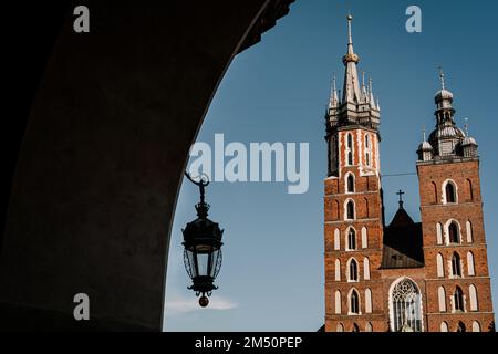 St. Basilique Marie à la place du marché dans la vieille ville de Cracovie, en Pologne. Vue à travers l'arcade avec lanterne. Banque D'Images