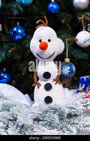 Bonhommes de neige tricotés en chapeaux et foulards colorés sur fond bleu. Le concept du conte de fées de Noël, du nouvel an et de l'hiver. Pose à plat Banque D'Images