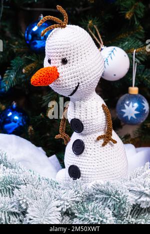 Bonhommes de neige tricotés en chapeaux et foulards colorés sur fond bleu. Le concept du conte de fées de Noël, du nouvel an et de l'hiver. Pose à plat Banque D'Images