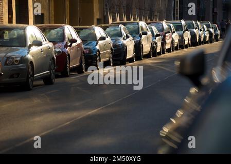 Voitures garées étroitement le long de la route dans la ville Banque D'Images