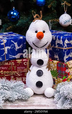 Bonhommes de neige tricotés en chapeaux et foulards colorés sur fond bleu. Le concept du conte de fées de Noël, du nouvel an et de l'hiver. Pose à plat Banque D'Images