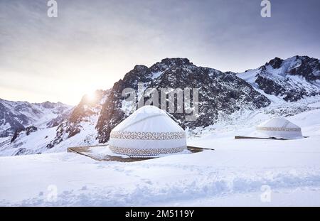 Hôtel et restaurant du complexe de maisons nomades Yurt à la station de ski de Shymbulak à Almaty, Kazakhstan. Hiver gelé matin lever de soleil éclat de soleil ou Banque D'Images