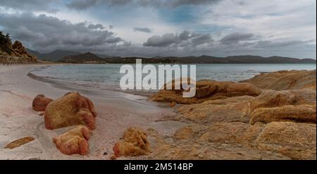 Vue sur le paysage Plage de Porto Giunco près de Villasimius en Sardaigne avec des blocs de granit rouge en premier plan Banque D'Images