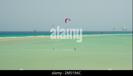 Des kiters et des surfeurs coupent les vagues de l'océan Atlantique sur la côte des îles Canaries. Sports extrêmes à Playa de Sotavento de Jandia, Fuerteventura Banque D'Images