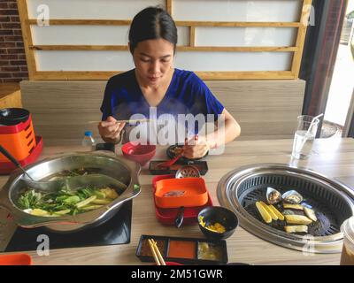 femme mangeant une variété d'aliments Banque D'Images