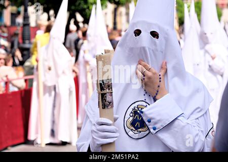 Confrères accompagnant les pasos dans l'itinéraire des 'Stations of Penance'. Yeux derrière le masque Banque D'Images