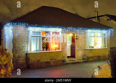 Les lumières de Noël sur le bungalow suburbain des années 1930 construit par john Lawrence aspirante classe moyenne sur la grande route de l'Ouest A82 Glasgow, Écosse, Royaume-Uni Banque D'Images