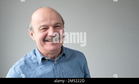 Homme de haut niveau gai qui regarde la caméra et sourit. Banque D'Images