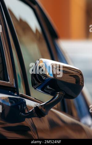 Photo verticale d'un miroir de vision latérale d'une vieille voiture d'époque sur un arrière-plan flou Banque D'Images