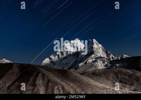 Étoile tomber au-dessus de l'Ama Dablam pic de montagne illuminée par un brillant clair de lune. Belle nuit paysage de montagne avec étoile floue de mouvement. Les sentiers des étoiles Banque D'Images