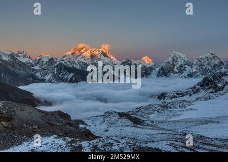 Magnifique coucher de soleil sur le sommet de l'Everest, vue depuis le col de Renjo la. Belle vue sur la vallée de la montagne remplie de nuages mauriquement. Pic de neige spectaculaire d'Everes Banque D'Images