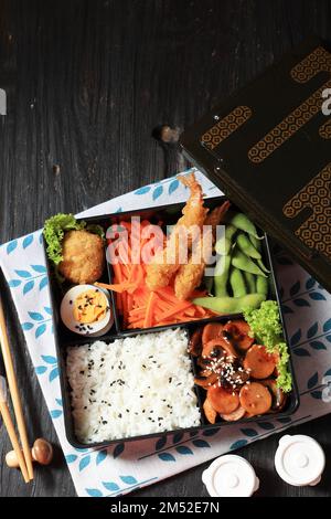 Boîte à Bento japonaise avec saucisses, pépites, œufs et crevettes Tempura. Vue de dessus avec espace de copie Banque D'Images