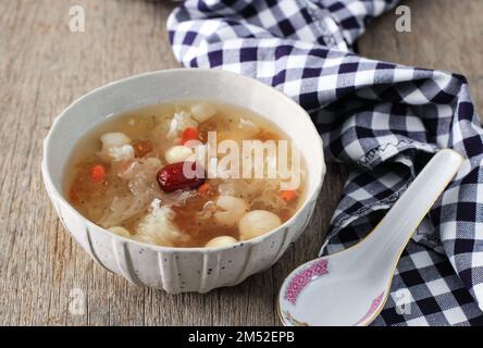 Soupe de Gum de pêche Tremella, boisson aux herbes chinoises sur table en bois rustique Banque D'Images