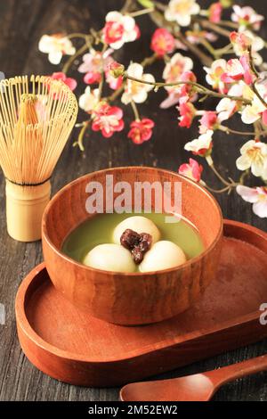 Matcha Tangyuan sur un bol en bois, surmonté d'un haricot rouge Adzuki Banque D'Images