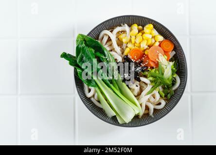 Top vue Udon avec légumes, concept sain Udon. Dans la table blanche, copiez l'espace pour le texte Banque D'Images