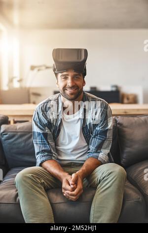 La technologie, pour l'avenir du cinéma à la maison. un jeune homme utilisant un casque de réalité virtuelle sur le canapé à la maison. Banque D'Images