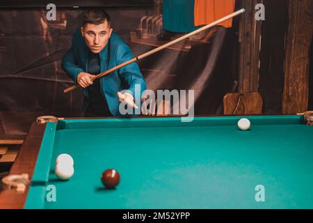 Jouer au billard, un homme comme un amateur joue au billard, un jeu de société de sports, des loisirs. Banque D'Images