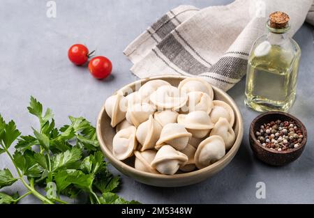 Boulettes de viande. Le plat traditionnel russe est le pelmeni sibérien. Servi avec des herbes fraîches, du beurre et des légumes en gros plan. Banque D'Images