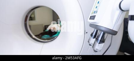 Un technologue en acquisition CT qui regarde le patient dans le scanner de tomodensitométrie pendant la préparation de la procédure. Femme entrant dans le scanner CT. Banque D'Images