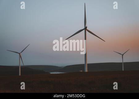 Éoliennes au coucher du soleil. Parc éolien. Source d'énergie renouvelable durable, effets sur le concept de l'environnement. Pays de Galles du Sud, Royaume-Uni Banque D'Images