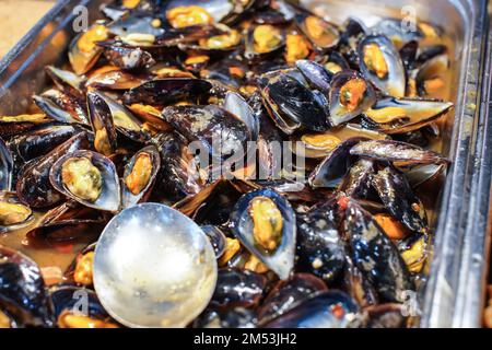 Moules noires et jaunes au restaurant buffet, détail en gros plan Banque D'Images