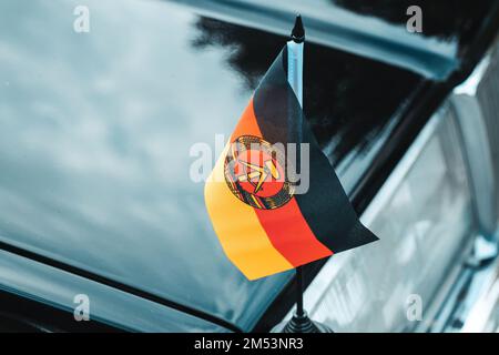 Ancien drapeau DDR, République démocratique d'allemagne, voiture noire, symboles communistes, ancien bloc de l'est Banque D'Images