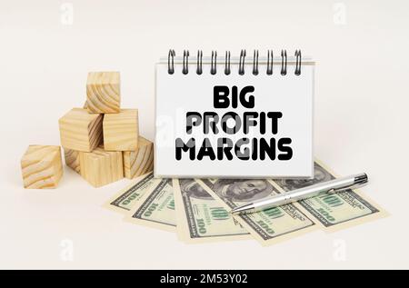 Concept d'entreprise. Sur une surface blanche, des cubes, des dollars, un stylo et un bloc-notes avec l'inscription - grandes marges bénéficiaires Banque D'Images