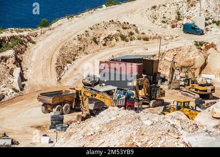 Une mine à ciel ouvert de pierre de marbre blanc avec des machines lourdes utilisées pour extraire et exploiter la pierre précieuse pour une utilisation et une production ultérieures Banque D'Images