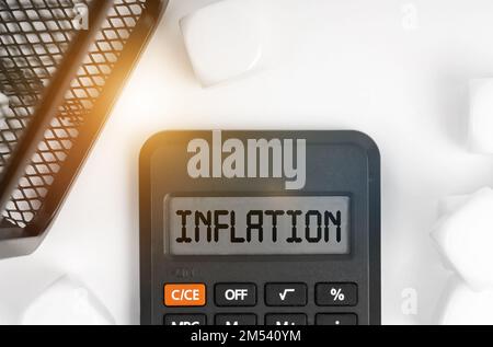 Concept d'entreprise. Sur la table se trouvent des cubes blancs, un panier noir et une calculatrice avec l'inscription - inflation Banque D'Images