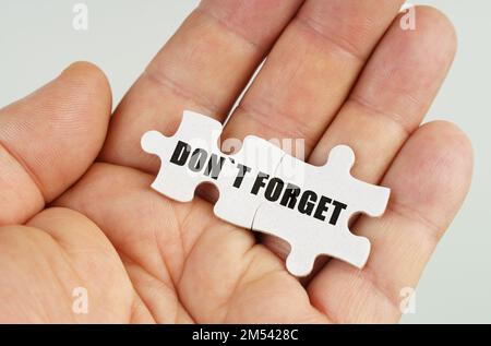 Concept d'entreprise. Dans la main d'un homme sont des puzzles avec l'inscription - n'oubliez pas Banque D'Images