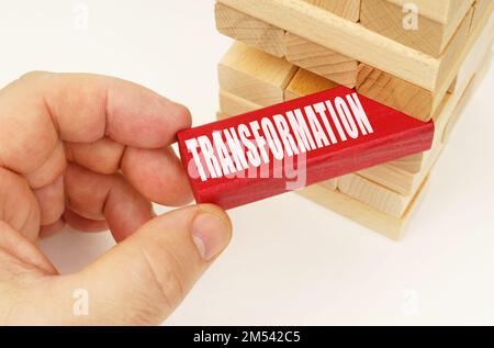 Concept d'entreprise et de technologie. De la tour avec des planches en bois, ils prennent une plaque rouge avec l'inscription - transformation Banque D'Images