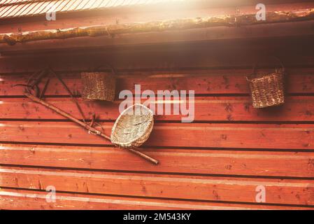 Vieux outils paysan accrochés sur un mur en bois sur une ferme animalière. Banque D'Images