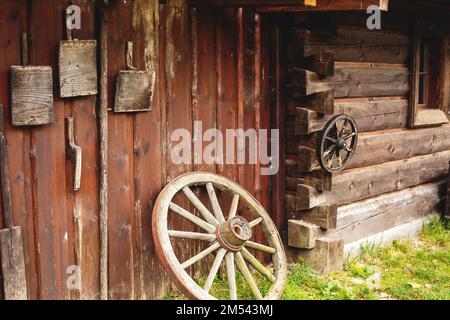 Vieux outils paysan accrochés sur un mur en bois sur une ferme animalière. Banque D'Images