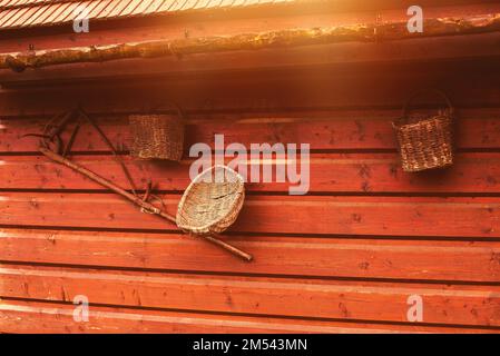 Vieux outils paysan accrochés sur un mur en bois sur une ferme animalière. Banque D'Images